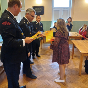 Milena Łucarz z kl. 4 a odbiera dyplom z rąk przedstawicieli Ochotniczej Straży Pożarnej w Szczurowej. Kliknięcie na zdjęcie spowoduje jego powiększenie do rozmiaru oryginalnego.