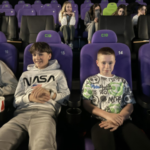 Uczniowie kl. 6 a siedzą w kinie w fotelach obok siebie. Uczestniczą w seansie filmowym. Kliknięcie na zdjęcie spowoduje jego powiększenie do rozmiaru oryginalnego. 