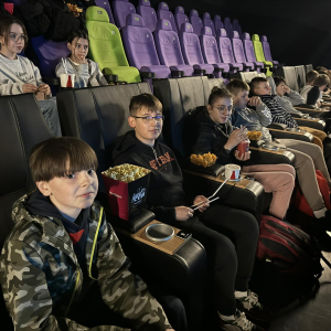 Młodzież z kl. 6 b siedzi w kinie. Oglądają film. Kliknięcie na zdjęcie spowoduje jego powiększenie do rozmiaru oryginalnego. 
