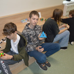 Uczniowie kl. 7 b bawią się kostkami Rubika na przerwie na łamigłówki.  Kliknięcie na zdjęcie spowoduje jego powiększenie do rozmiaru oryginalnego.